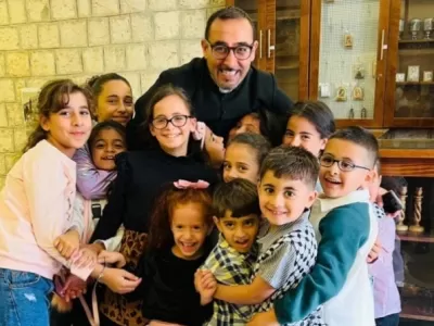 Father Bashar Fawadleh, Latin rite pastor of Taybeh, with children from his community.